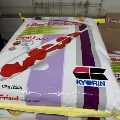 Gestapelde zakken Hikari Friend medium pellet van 10 kg met rood-witte koi en het Kyorin-logo